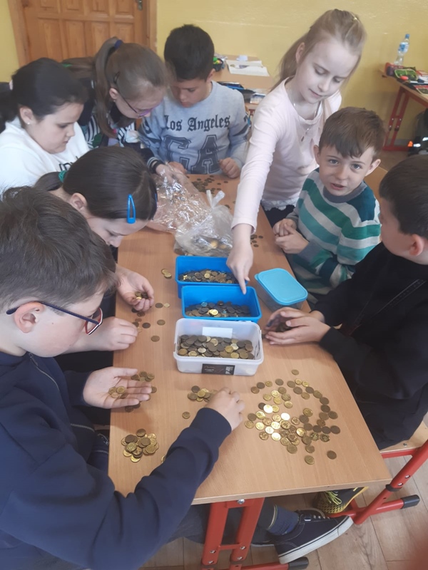 Dzieci segregujące monety groszowe