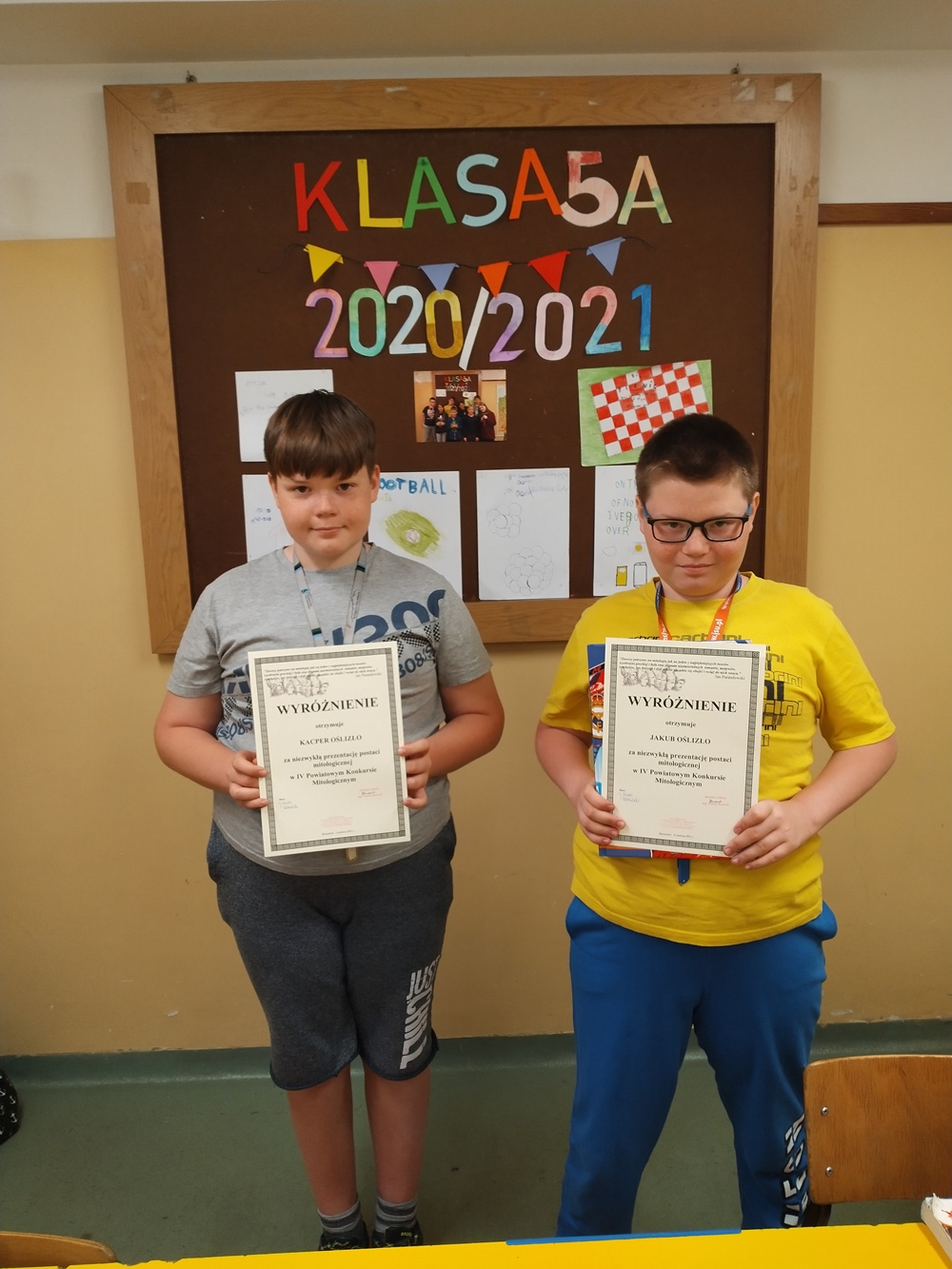 Dwaj chłopcy trzymający w ręku dyplom