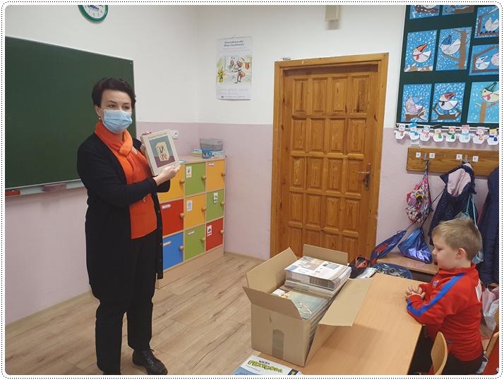 Pani bibliotekarka trzymająca w ręce książkę