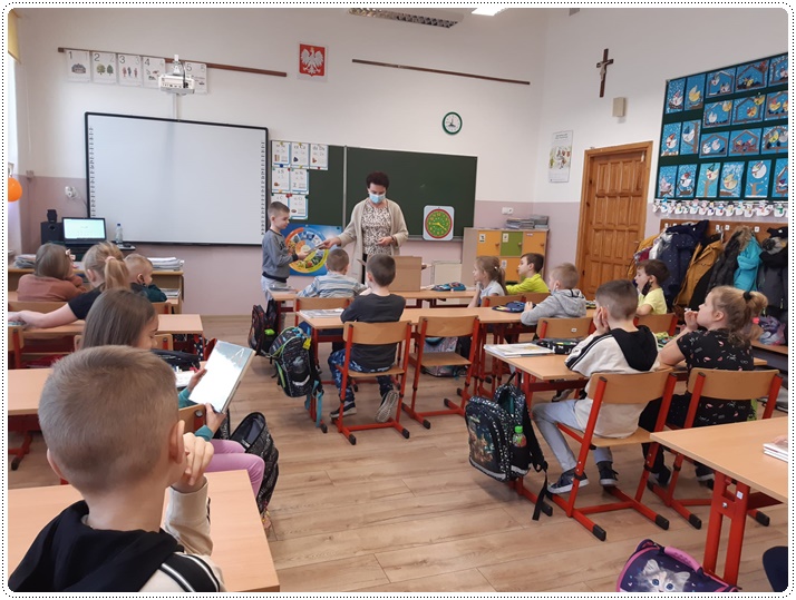 Siedzący w ławkach uczniowie, z przodu klasy bibliotekarka