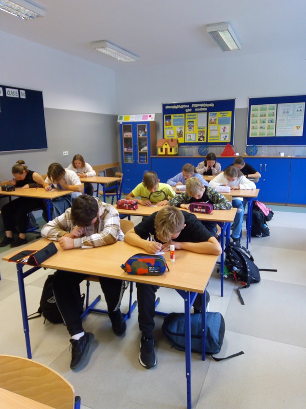 Światowy Dzień Tabliczki Mnożenia. Uczniowie siedzą w ławkach, rozwiązują zadania.