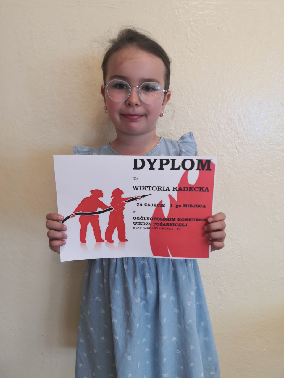 Uczestniczka konkursy z dyplomem w dłoniach