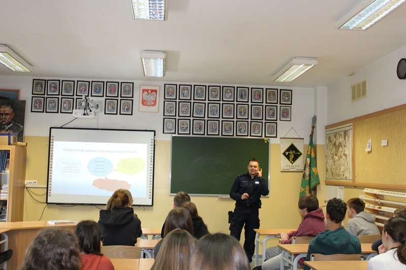 Policjant, w tle uczniowie